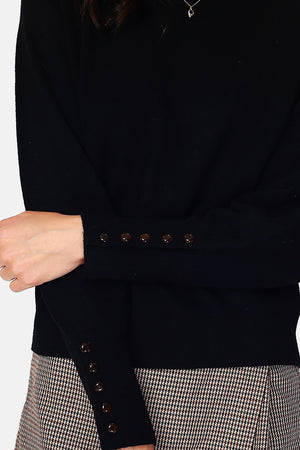 Wide sweater with round neckline and slightly puffed long sleeves with button placket at the bottom of the sleeve