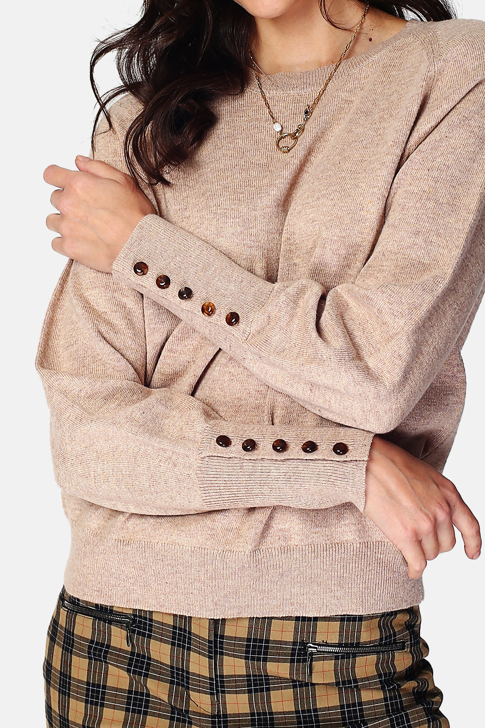 Wide sweater with round neckline and slightly puffed long sleeves with button placket at the bottom of the sleeve