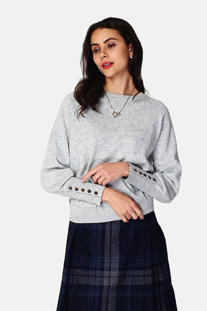 Wide sweater with round neckline and slightly puffed long sleeves with button placket at the bottom of the sleeve