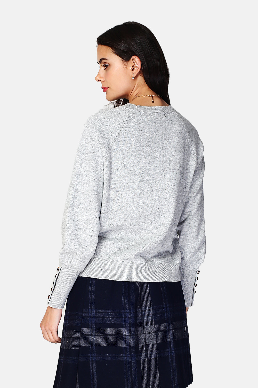 Wide sweater with round neckline and slightly puffed long sleeves with button placket at the bottom of the sleeve
