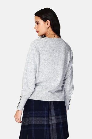 Wide sweater with round neckline and slightly puffed long sleeves with button placket at the bottom of the sleeve