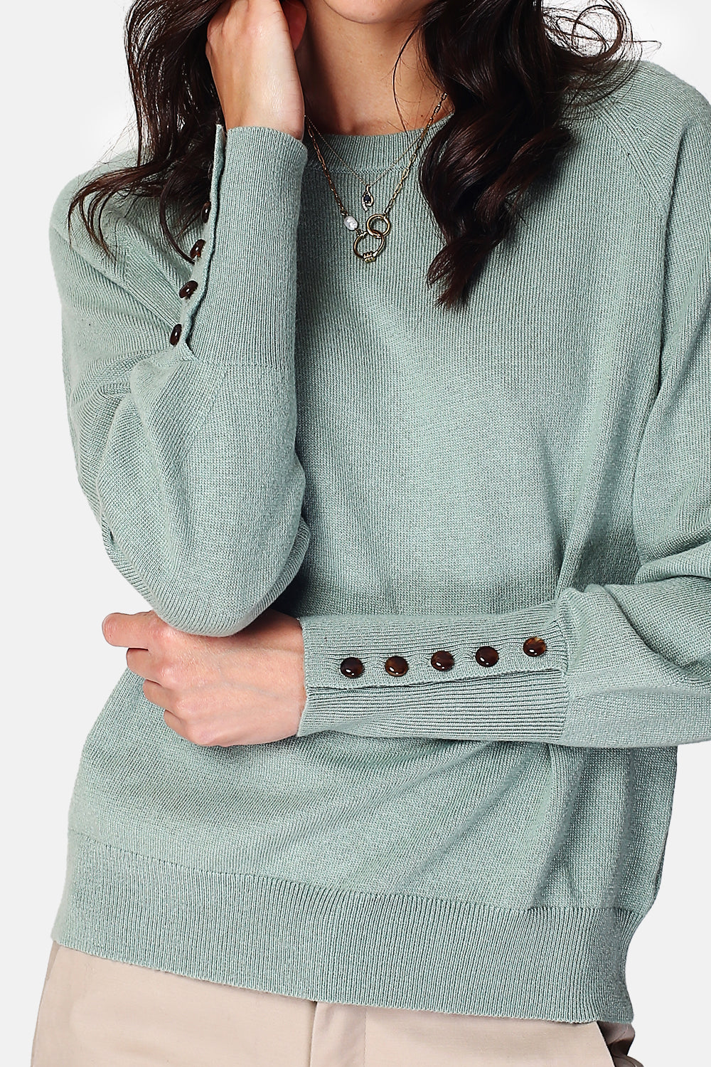 Wide sweater with round neckline and slightly puffed long sleeves with button placket at the bottom of the sleeve