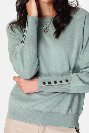 Wide sweater with round neckline and slightly puffed long sleeves with button placket at the bottom of the sleeve