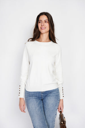Wide sweater with round neckline and slightly puffed long sleeves with button placket at the bottom of the sleeve