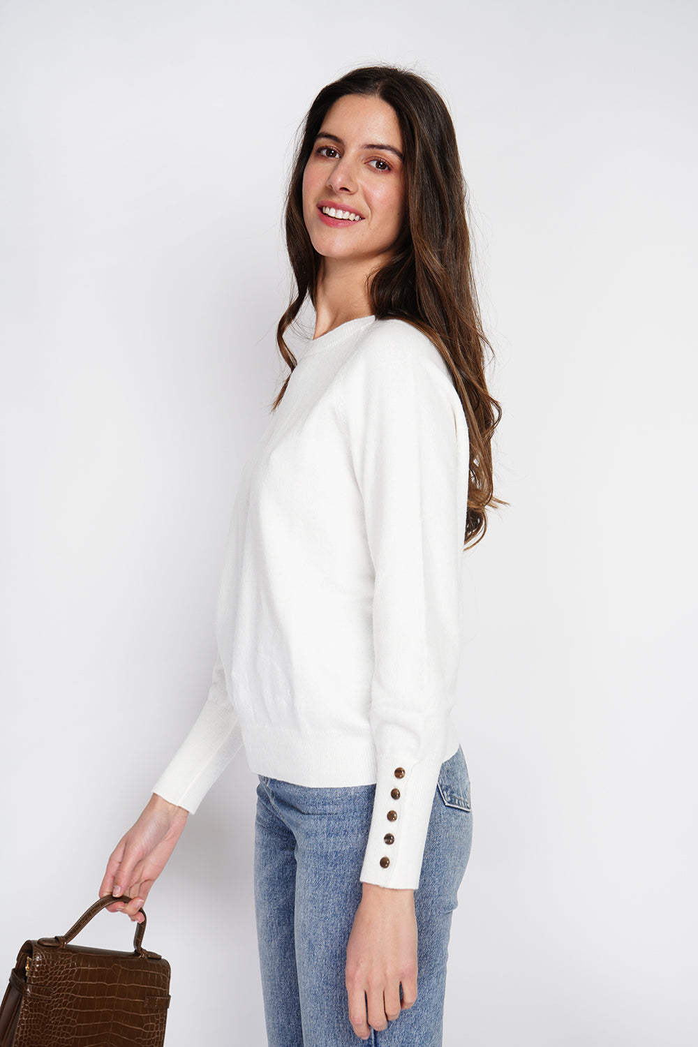 Wide sweater with round neckline and slightly puffed long sleeves with button placket at the bottom of the sleeve