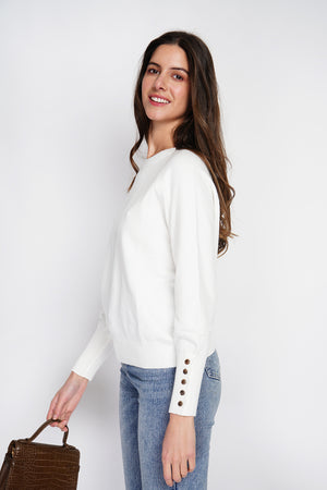Wide sweater with round neckline and slightly puffed long sleeves with button placket at the bottom of the sleeve