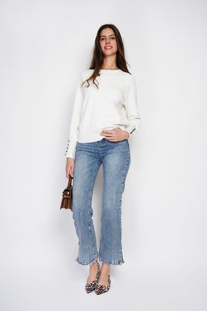 Wide sweater with round neckline and slightly puffed long sleeves with button placket at the bottom of the sleeve