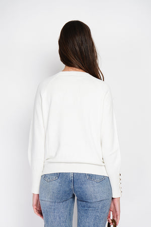 Wide sweater with round neckline and slightly puffed long sleeves with button placket at the bottom of the sleeve