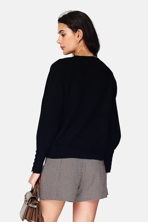 Wide sweater with round neckline and slightly puffed long sleeves with button placket at the bottom of the sleeve