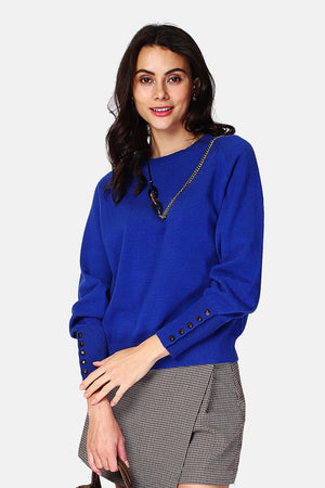 Wide sweater with round neckline and slightly puffed long sleeves with button placket at the bottom of the sleeve