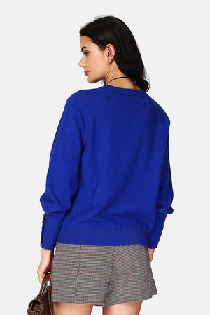 Wide sweater with round neckline and slightly puffed long sleeves with button placket at the bottom of the sleeve