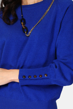 Wide sweater with round neckline and slightly puffed long sleeves with button placket at the bottom of the sleeve