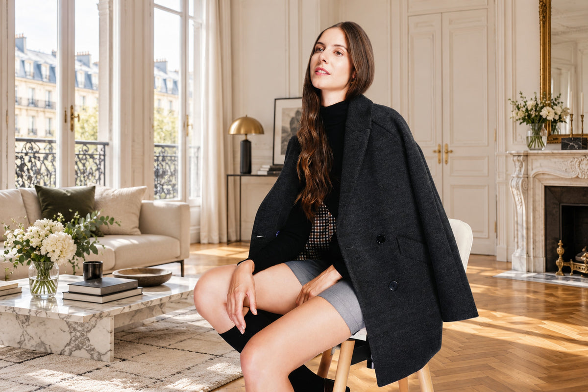 Woman in a black wool coat in a Parisian apartment