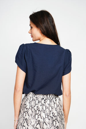 Top with flap collar, buttons on the front and short sleeves