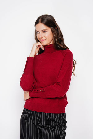 Oversized turtleneck sweater with button placket at the bottom of the long sleeves