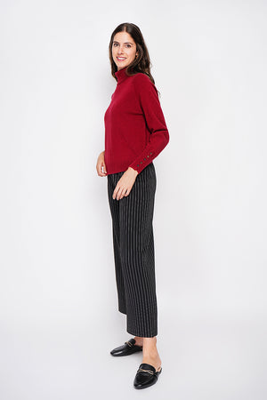 Oversized turtleneck sweater with button placket at the bottom of the long sleeves