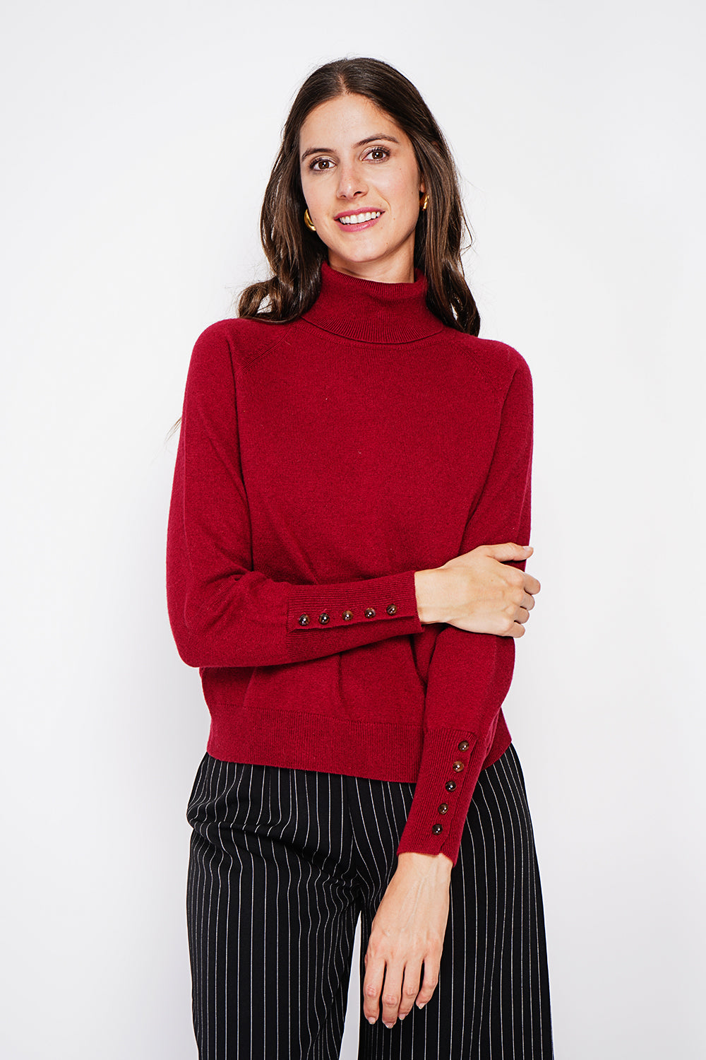 Oversized turtleneck sweater with button placket at the bottom of the long sleeves