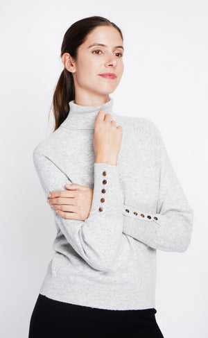 Oversized turtleneck sweater with button placket at the bottom of the long sleeves