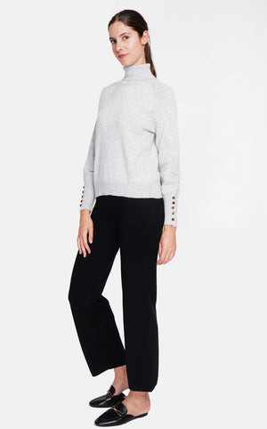 Oversized turtleneck sweater with button placket at the bottom of the long sleeves