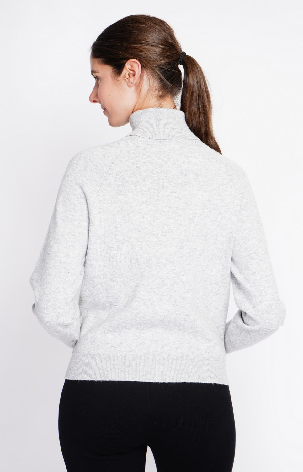 Oversized turtleneck sweater with button placket at the bottom of the long sleeves