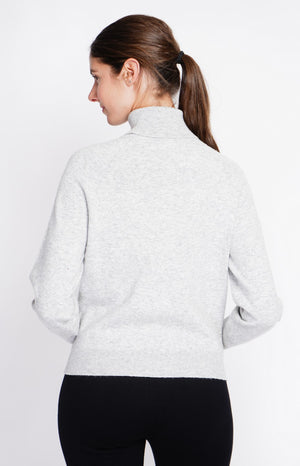 Oversized turtleneck sweater with button placket at the bottom of the long sleeves
