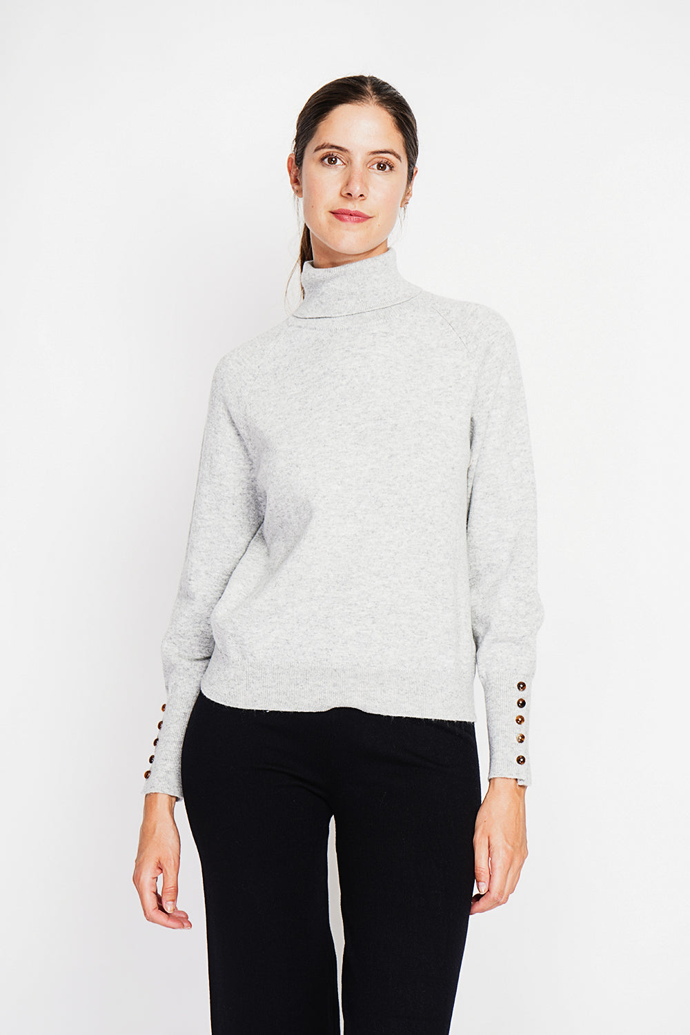 Oversized turtleneck sweater with button placket at the bottom of the long sleeves