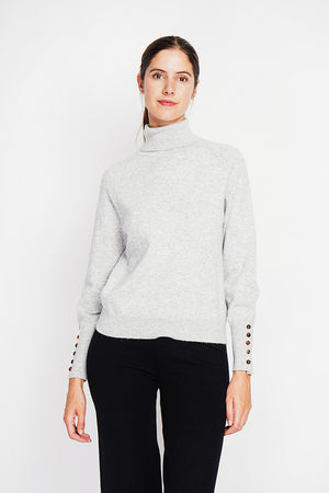 Oversized turtleneck sweater with button placket at the bottom of the long sleeves