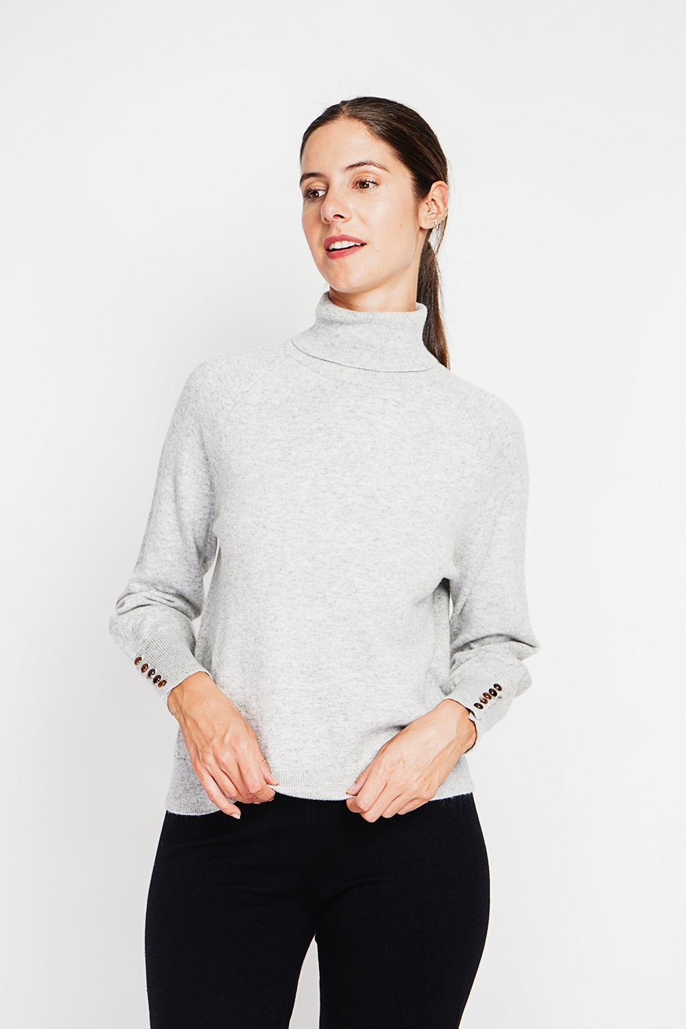 Oversized turtleneck sweater with button placket at the bottom of the long sleeves