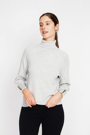 Oversized turtleneck sweater with button placket at the bottom of the long sleeves