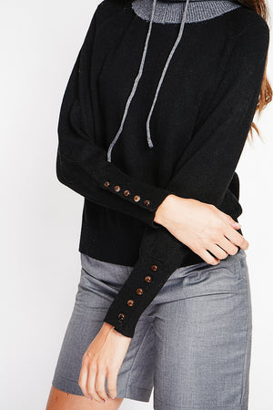 Oversized turtleneck sweater with button placket at the bottom of the long sleeves