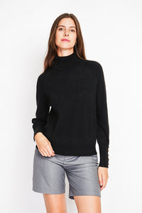 Oversized turtleneck sweater with button placket at the bottom of the long sleeves