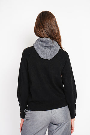 Oversized turtleneck sweater with button placket at the bottom of the long sleeves