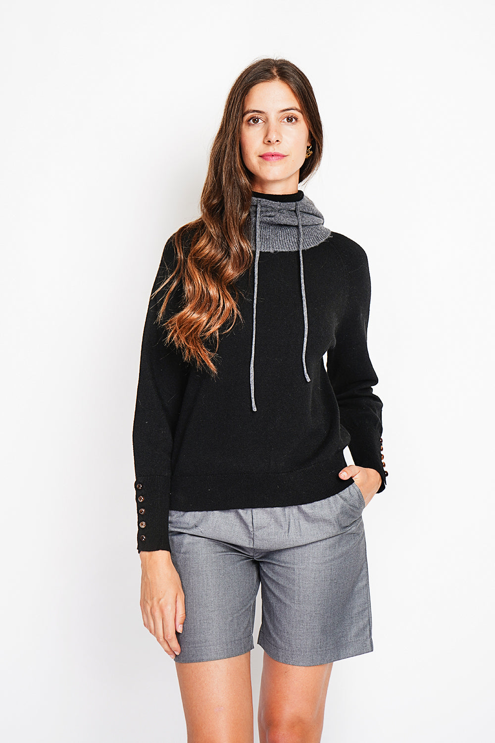 Oversized turtleneck sweater with button placket at the bottom of the long sleeves