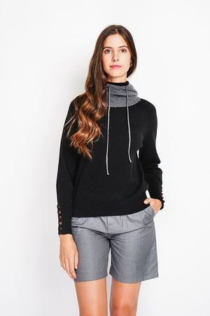 Oversized turtleneck sweater with button placket at the bottom of the long sleeves