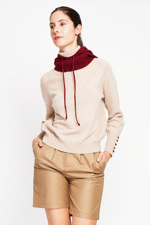 Oversized turtleneck sweater with button placket at the bottom of the long sleeves
