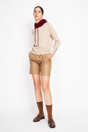 Oversized turtleneck sweater with button placket at the bottom of the long sleeves