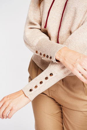 Oversized turtleneck sweater with button placket at the bottom of the long sleeves