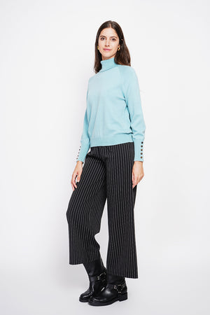 Oversized turtleneck sweater with button placket at the bottom of the long sleeves