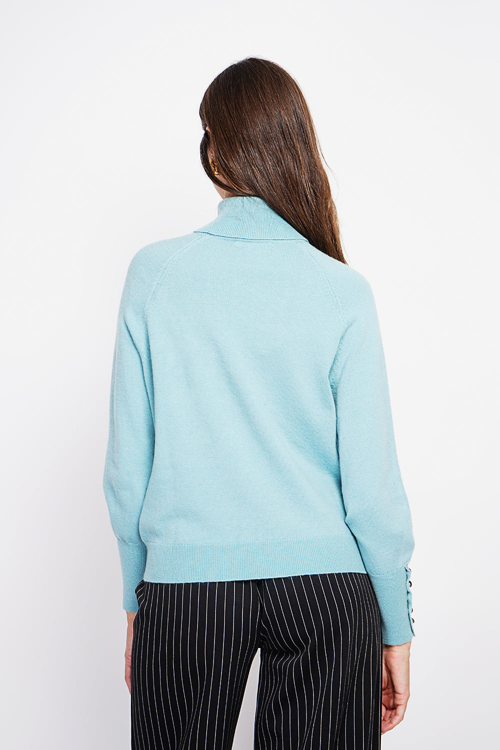 Oversized turtleneck sweater with button placket at the bottom of the long sleeves