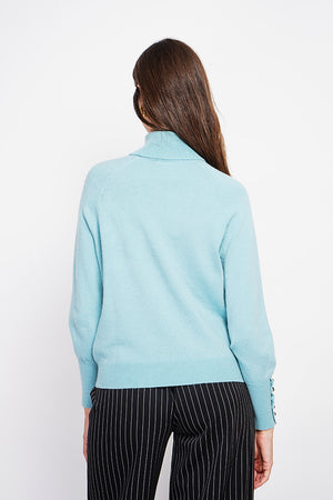 Oversized turtleneck sweater with button placket at the bottom of the long sleeves
