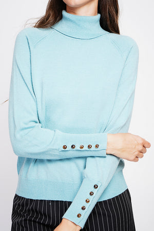 Oversized turtleneck sweater with button placket at the bottom of the long sleeves