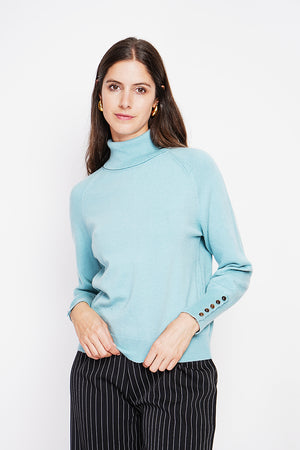Oversized turtleneck sweater with button placket at the bottom of the long sleeves